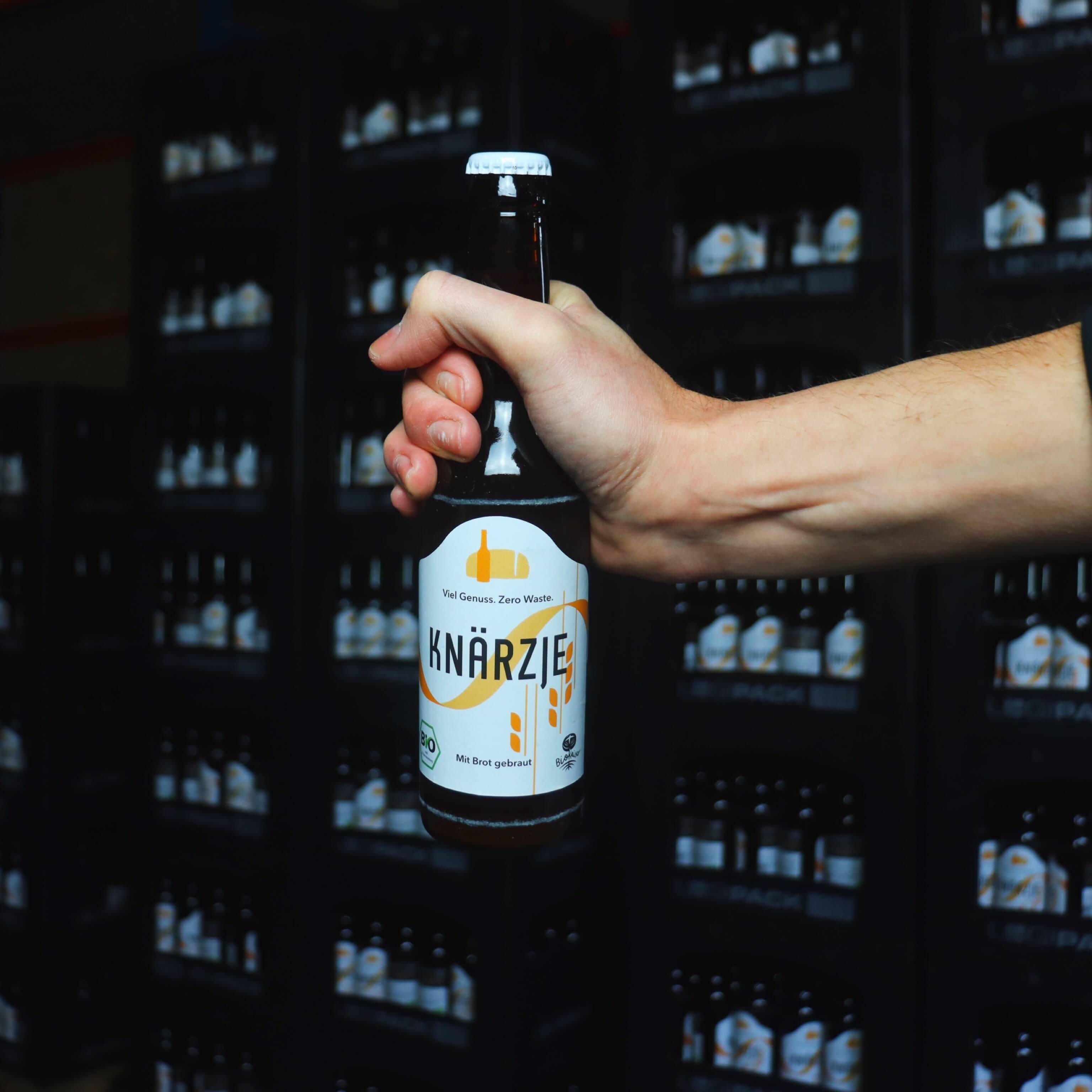 c Knärzje GmbH – Knärzje Flasche vor Kästen